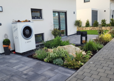 Vorgarten mit Wasserspiel aus Naturstein-Findling, Beeten und Terrasse