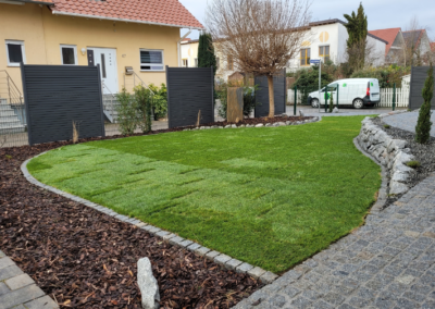 Gartengestaltung mit geschwungenen Formen, Natursteinen und Rollrasen